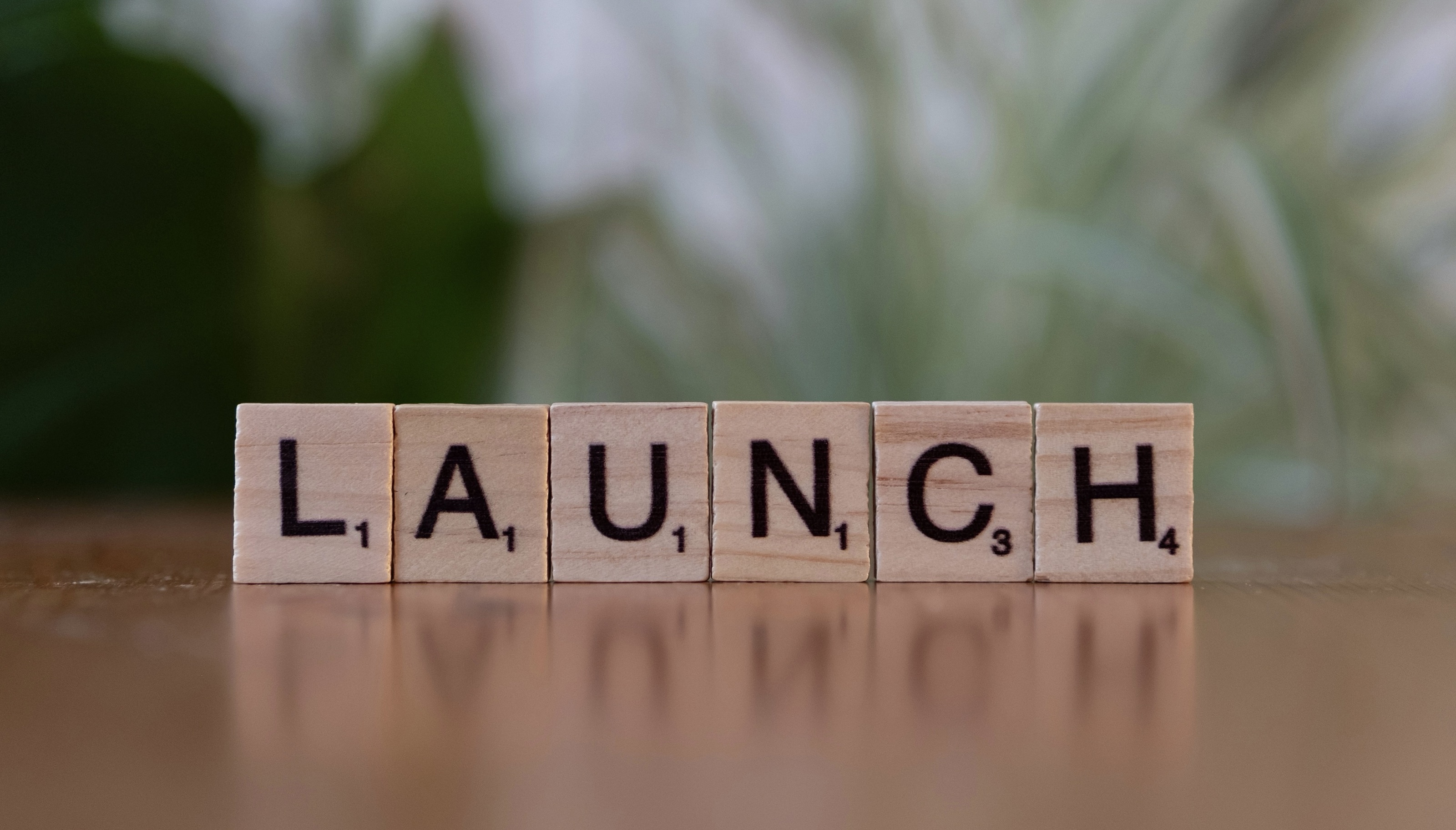 The word 'Launch' spelled with Scrabble tiles.