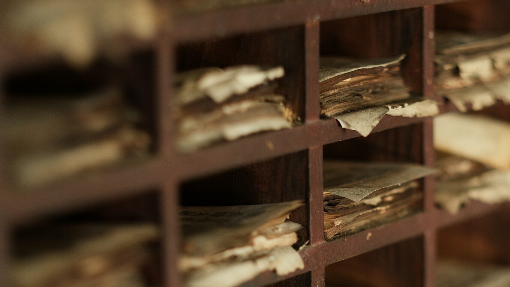 A wall of old wooden pigeonholes crammed with aged, curling, unanswered papers